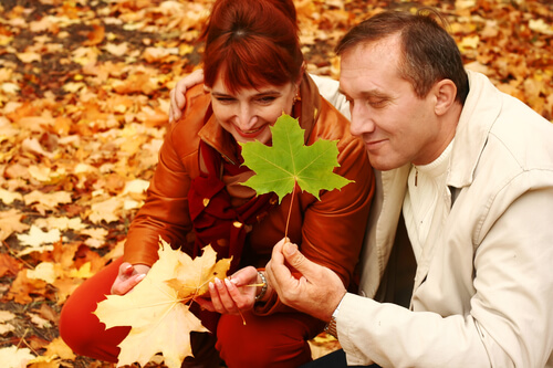 mature couple enjoying looking at autumn leaves